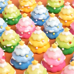 Colorful resin Christmas tree miniatures with star tops on vibrant orange background