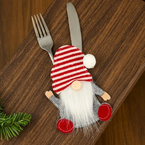 Christmas gnome cutlery holder with red stripes on a rustic dark wood table setting
