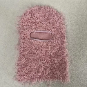 Detail of pink faux fur texture on a warm knitted Balaclava face mask for winter