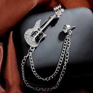 Detailed view of silver guitar brooch with rhinestones and elegant hanging chains