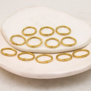Set of 12 gold plated titanium steel zodiac rings featuring crystals and celestial symbols