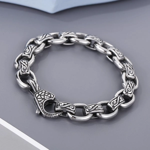 Macro detail of men's vintage engraved square links and stainless steel chain bracelet