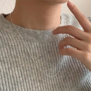 Close-up of a minimalist 925 sterling silver bead chain necklace worn by a model