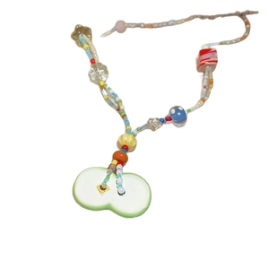 Colorful beaded necklace with a light green ceramic pendant on a plain white background