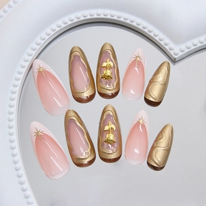 Faux ongles français avec roses 3D dorées et étoiles sur forme amande longue élégante