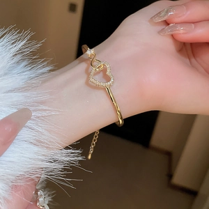 Detailed view of hollow heart-shaped gold bracelet with sparkling zircon pave settings