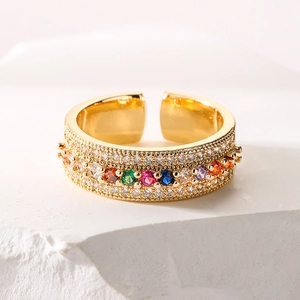 Luxurious 18K gold-plated ring with rainbow zircons on a minimalist stone base