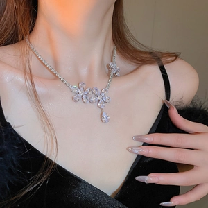 Detailed view of flower necklace with sparkling zircon stones and a water drop pendant