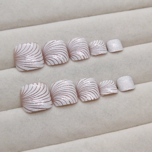Sparkling white press-on toenails with brown shell pattern and fine glitter finish