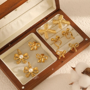 Minimalist 18k gold plated stainless steel bow jewelry set with pearls on wooden display