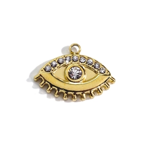 Macro detail of gold evil eye pendant with sparkling rhinestones and clear crystals