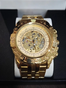 Macro shot of gold skeleton mechanical watch with visible gears and telemeter dial