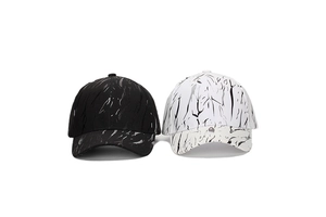 Detail view of black and white baseball caps featuring artistic marble pattern textures
