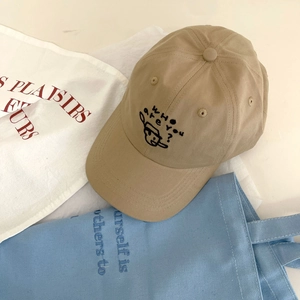Detail der khakifarbenen Baumwoll-Baseballkappe mit Charakter-Stickerei und Text-Logo