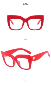 Macro view of red oversized cat-eye frame glasses with golden square metal rivets