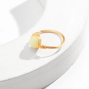 Macro shot of handmade gold wire-wrapped ring with a translucent yellow stone detail
