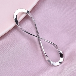 Polished silver stainless steel infinity pendant resting on soft pink silk fabric