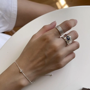 Detail of 925 sterling silver box chain bracelet with blue gemstone ring on model's hand