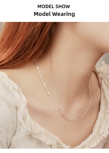 Detail of 925 sterling silver beaded necklace on model wearing white lace top