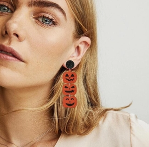 Three-tier Halloween pumpkin drop earrings worn by a model for a festive spooky look