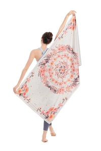 Detail view of microfiber beach towel featuring a large vibrant mandala floral pattern