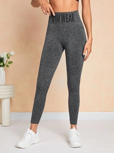 Détail du legging de yoga gris taille haute avec texte GYM WEAR et design minimaliste