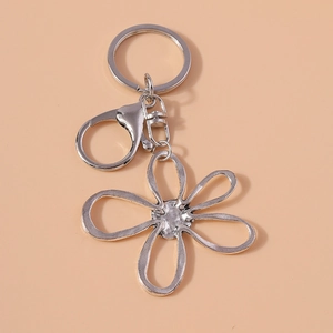 Elegant silver hollow flower keychain with lobster clasp and swivel ring on beige background