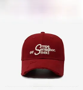 Close-up of vintage distressed details and 3D embroidery on a dark red baseball cap