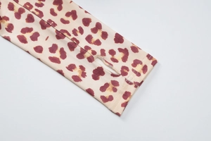 Detailed close-up of leopard print sleeve cuff featuring a functional thumbhole design