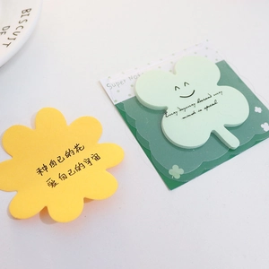 Close-up of flower and clover shaped sticky notes with inspirational text and packaging