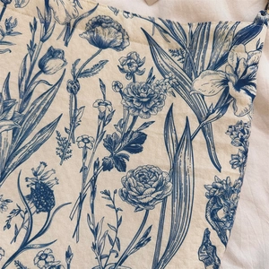 Close-up of blue floral print on vintage beige cotton fabric for a hobo shoulder bag