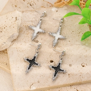 Detail view of gothic cross earrings with black and white enamel on a stone surface