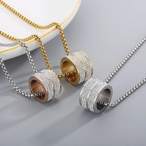 Close-up of triple hip-hop cylinder pendants with crystals in gold, silver and rose gold