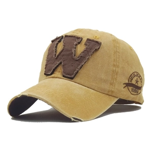 Close-up of vintage mustard yellow washed cotton baseball cap with embroidered W patch