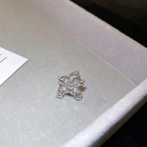 Close-up of silver ear cuff with four marquise-cut zircons on a gray velvet box