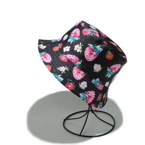 Close-up of black fisherman hat with cute strawberry print on a metal stand