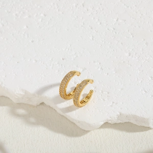Close-up of gold-plated ear cuffs with rows of sparkling pavé cubic zirconia