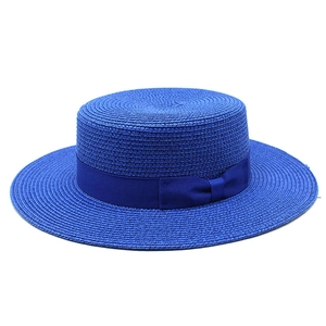 Close-up of a royal blue flat-top boater straw hat featuring a matching grosgrain bow