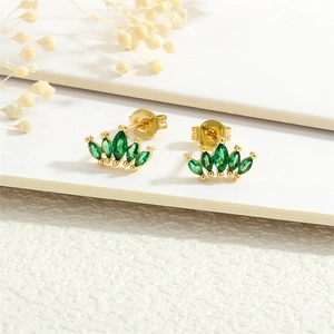 Macro shot of 18K gold plated leaf earrings with emerald green marquise cut zircons