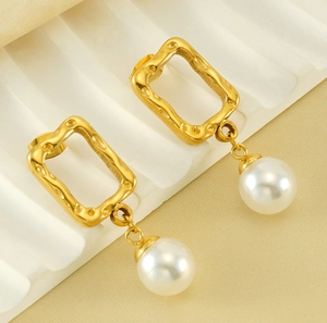 Detailed close-up of retro square hammer-textured gold earrings with drop pearls