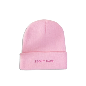 Close-up of pink cuffed beanie featuring embroidered I DON'T CARE text detail