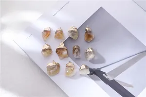 Macro shot of natural crystal raw stone pendants with gold-plated irregular metal edges