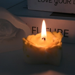 Brennende Duftkerze in Rosenform in Hellgelb mit heller Flamme und feinen Blütenblatt