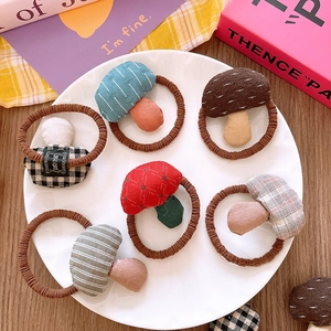 Set of seven handmade fabric mushroom elastic hair ties with diverse plaid patterns