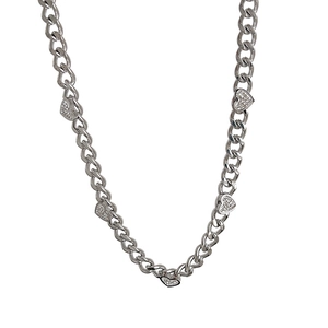 Silver tone Cuban chain necklace with five sparkling rhinestone heart charms on white background