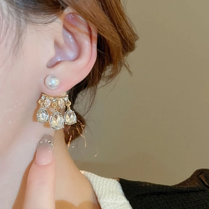 Detailed view of gold pearl tassel earrings with water-drop shaped sparkling zircons
