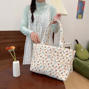 Detailed close-up of the quilted fabric texture and cute floral bear print on tote bag
