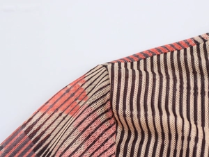 Gros plan sur la texture du tissu en maille rayé orange et beige avec coutures