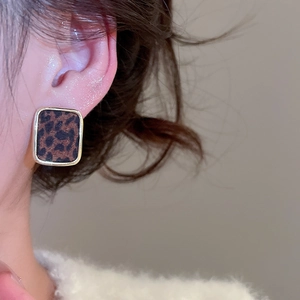 Gros plan de la boucle d'oreille carrée motif léopard avec bordure dorée