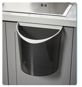 Detail view of wall-mounted transparent grey kitchen bin hanging on cabinet door